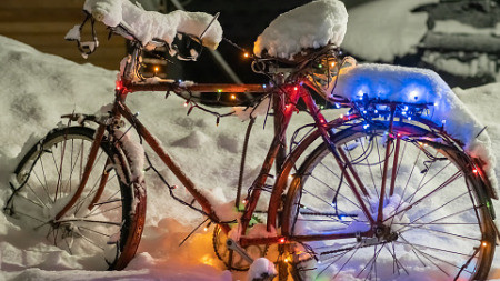 Schneebedecktes Fahrrad mit Lichterkette