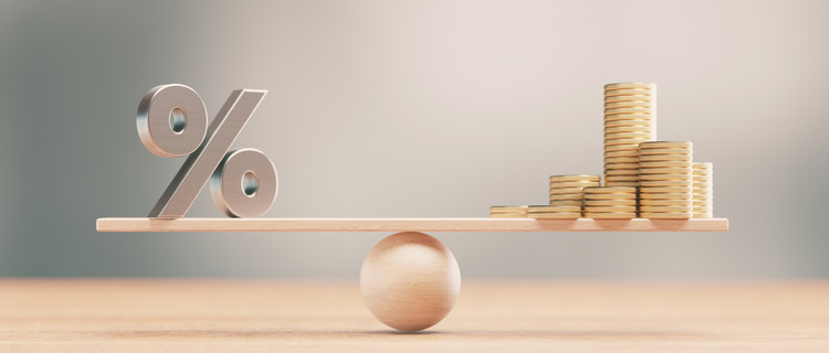 Das Prozentzeichen und Geldmünzen auf einer Holzwaage