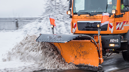 Front eines Schneepflug-Lkws auf verschneiter Straße