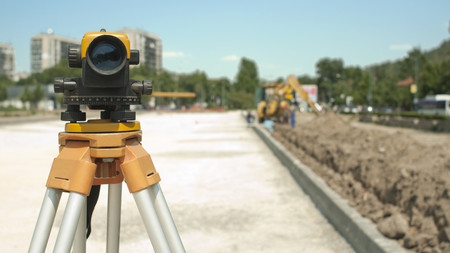Vermessungsgerät neben einer Baustelle